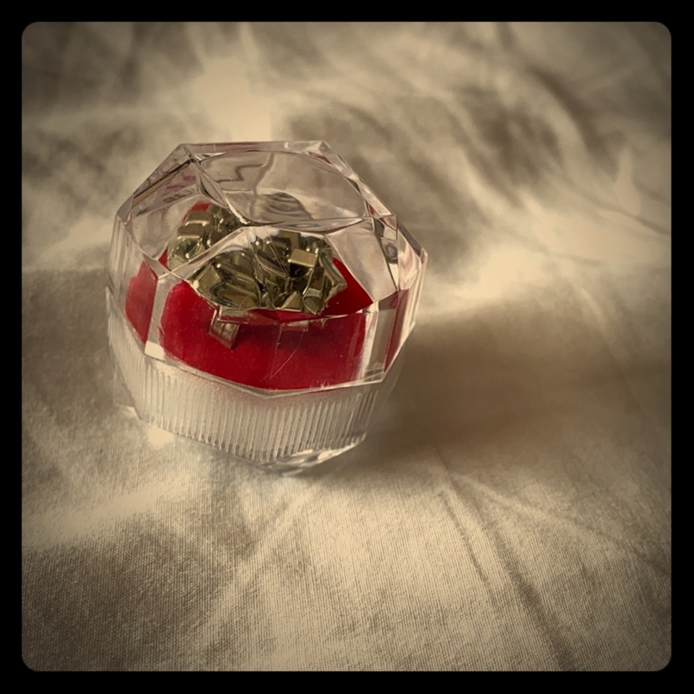 A ring that comes in container with a red cushion